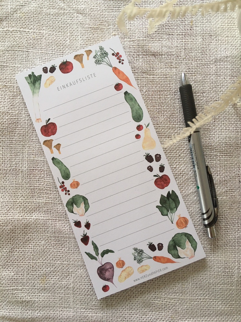 Puede incluir: Un bloc de notas de lista de la compra blanco con un borde de ilustraciones de verduras y frutas dibujadas a mano con acuarela. El texto "EINKAUFLISTE" est&aacute; en la parte superior del bloc de notas.
