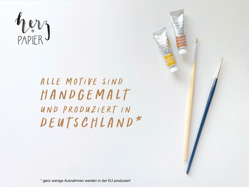 May include: A white background with the text "hevy PAPIER" in black script. The text "ALLE MOTIVE SIND HANDGEMALT UND PRODUZIERT IN DEUTSCHLAND*" is written in brown script. Two tubes of paint and two paintbrushes are on the right side of the image. The text "*ganz wenige Ausnahmen werden in der EU produziert" is at the bottom of the image.