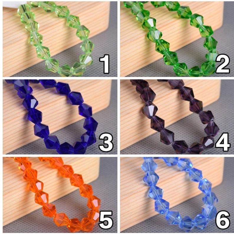 May include: A collection of six strands of faceted bicone beads in various colors, including light green, grass green, deep blue, dark purple, bright orange, and light blue. Each strand is numbered from one to six in white text on the image.