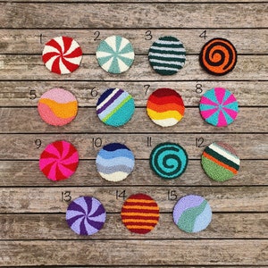 May include: Fifteen colorful round wool rug designs with numbers 1 through 15. The designs include swirls, stripes, and geometric patterns in various colors, including red, blue, green, yellow, orange, and purple.