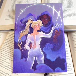 Puede incluir: Una ilustración muestra dos figuras en una escena celestial. Una mujer rubia con un mono blanco es abrazada por una figura con una capa con capucha azul. La obra de arte está ambientada sobre un fondo de nubes púrpuras arremolinadas y un halo estrellado.