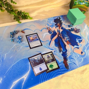 Puede incluir: Alfombrilla de juego azul y blanca con una ilustración de fantasía de un personaje con abrigo azul, con rayos y efectos de agua. También hay varias cartas de Magic: The Gathering, dados y una caja de cartas verde.