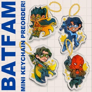 Puede incluir: Cuatro mini llaveros acrílicos con personajes de cómics. Cada llavero representa un personaje diferente en una pose dinámica, con colores vibrantes y detalles de estrellas. Los llaveros están sujetos a cadenas de cuentas doradas. El texto en la imagen dice "BATFAM MINI KEYCHAIN PREORDER!"