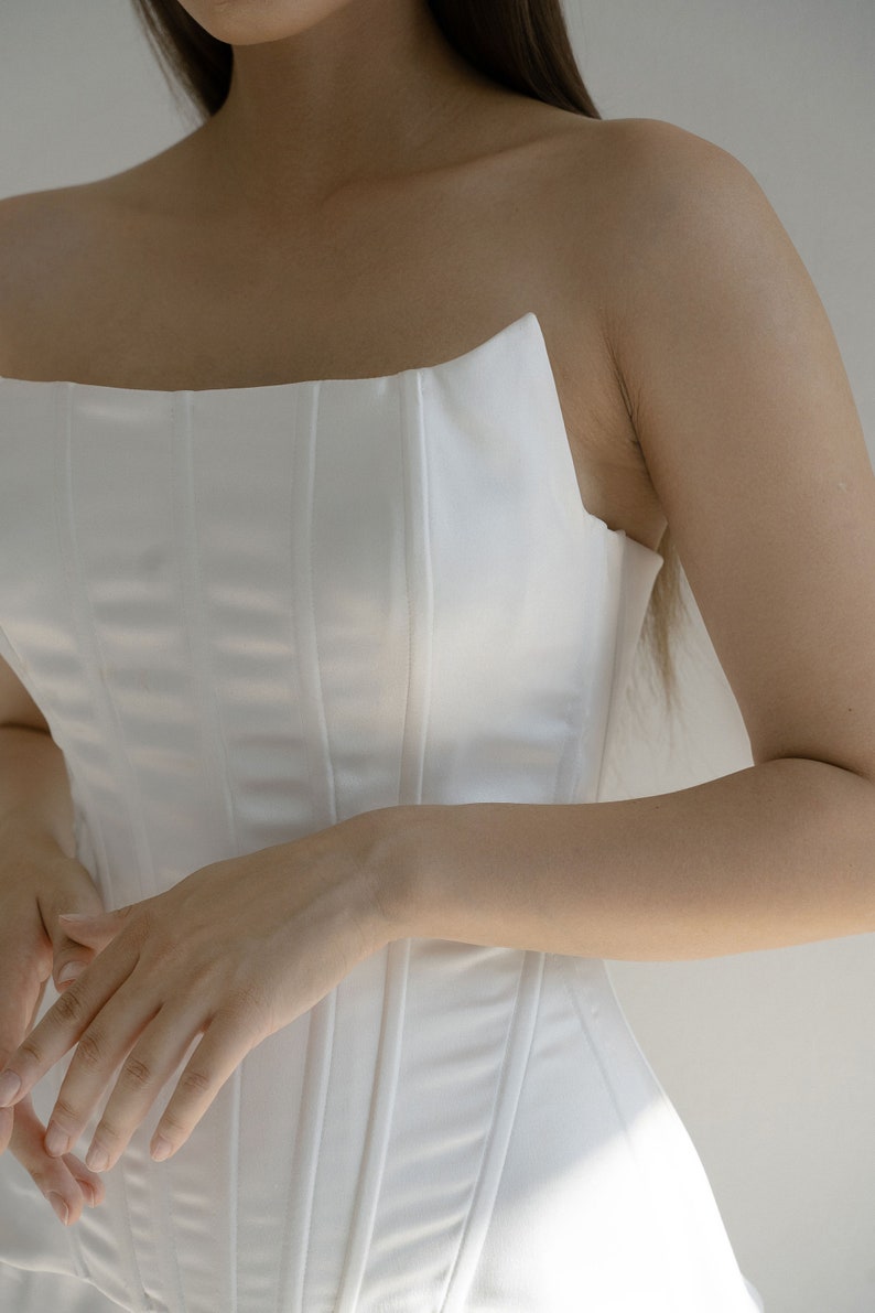 May include: A white strapless corset with vertical seams.