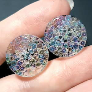 Könnte beinhalten: Ein Set aus drei Keramikbechern mit gesprenkelter, matter Oberfläche. Die Becher sind in Creme-, Hellgrau- und Dunkelgrautönen gehalten. Jeder Becher hat ein schlichtes, minimalistisches Design, ideal für Kaffee oder Tee.