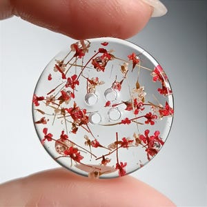 Może przedstawiać: Biały ceramiczny kubek z czarnym uchwytem i napisem "But First, Coffee" pogrubioną, czarną czcionką. Kubek jest ustawiony na rozmytym tle, sugerującym przytulne otoczenie.