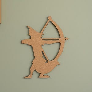 May include: A wooden silhouette of an archer with a bow and arrow, mounted on a pale green wall. The archer is depicted in a dynamic pose, aiming at a target. The artwork is a decorative piece.