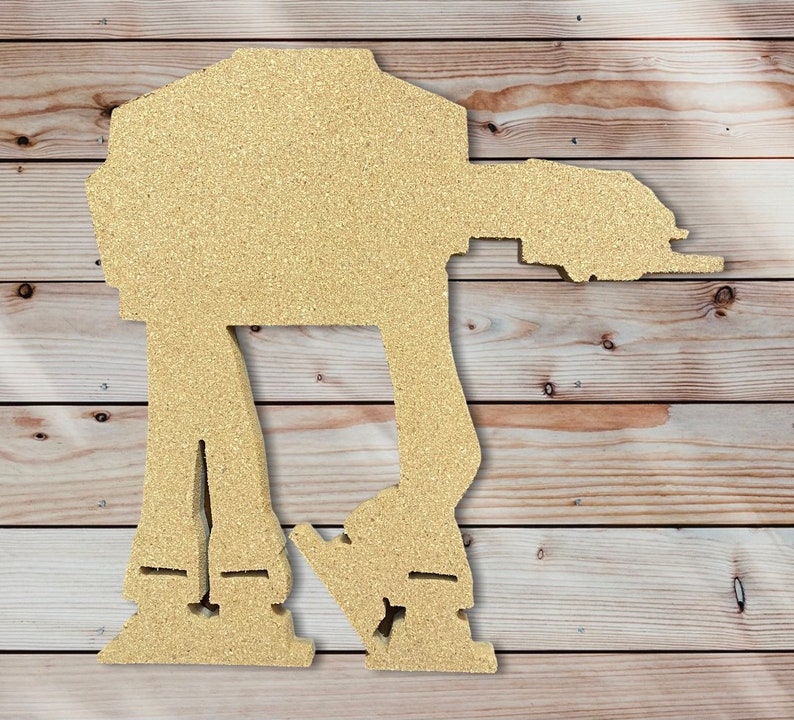 May include: A beige wooden cutout of a Star Wars AT-AT walker. The walker is standing on a woodgrain background.