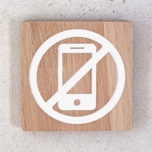 No smartphone sign. Wooden sign with engaved no cell phone icon. Mobile phone not allowed. No mobile phone please.