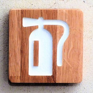 May include: A white fire extinguisher symbol carved into a wooden plaque.