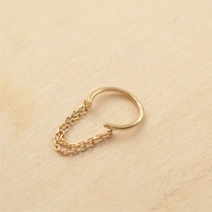 Peut inclure: Boucle d'oreille en or avec une double chaîne qui pend.
