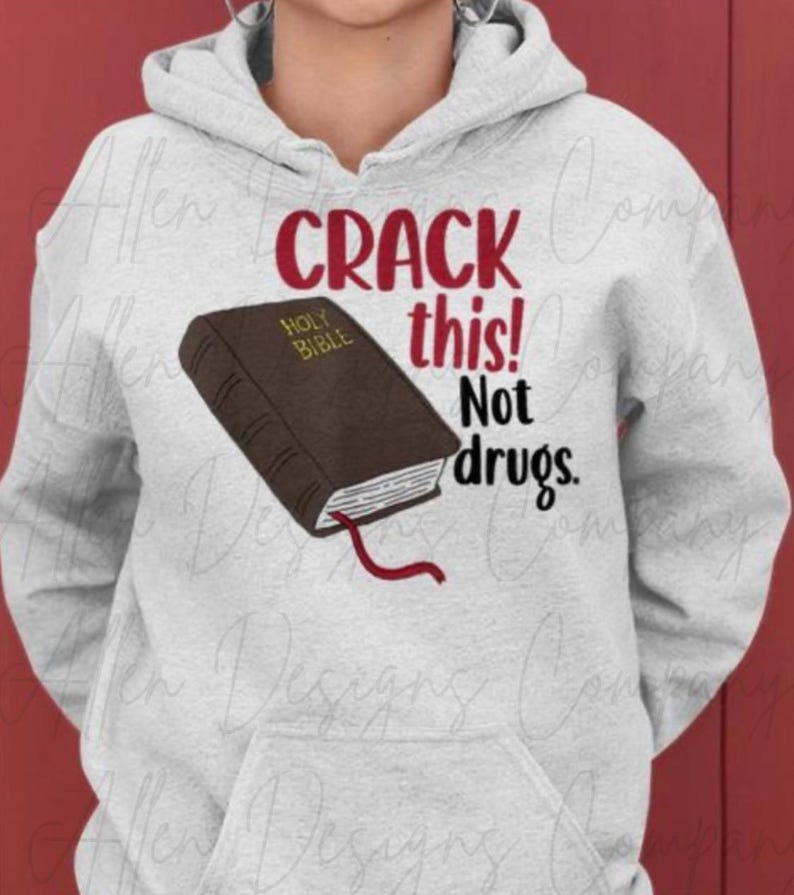 May include: Grey hoodie with the text "CRACK this! Not drugs." and a brown book with the text "HOLY BIBLE" on it.