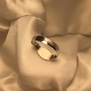 May include: A silver signet ring with a blank oval space for engraving.
