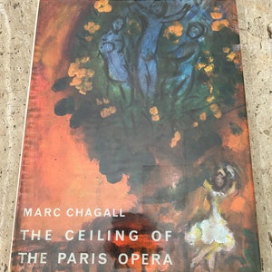 May include: A book cover with a colorful painting of people in a tree with yellow flowers. The title of the book is "Marc Chagall The Ceiling of The Paris Opera".