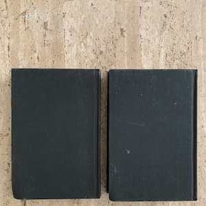 May include: Two black hardcover books with plain covers.