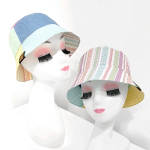 以下が含まれることがあります： ピンク、ブルー、イエローの組み合わせのパッチワークデザインと、ピンク、イエロー、グリーンのストライプデザインの2つのカラフルなバケットハット