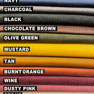 May include: A collection of corduroy fabric swatches stacked horizontally, featuring the colors navy, charcoal, black, chocolate brown, olive green, mustard, tan, burnt orange, wine, dusty pink, and stone, each labeled with its respective name.