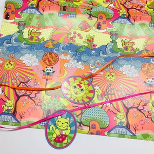 May include: A colorful wrapping paper with a whimsical design featuring cartoon animals, flowers, and geometric patterns. The paper is decorated with orange and pink ribbons.
