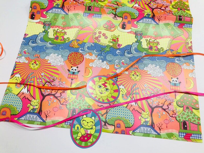 May include: A colorful wrapping paper with a whimsical design featuring cartoon animals, flowers, and geometric patterns. The paper is decorated with orange and pink ribbons.