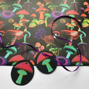 Puede incluir: Papel de regalo negro con un patr&oacute;n de setas coloridas, con setas rojas, naranjas, verdes y moradas. Dos etiquetas de regalo redondas negras con un dise&ntilde;o de seta roja y blanca y una cinta morada.