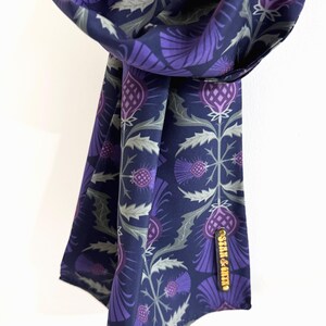 May include: A purple and green patterned silk scarf with a gold label that says "Stair & Co."
