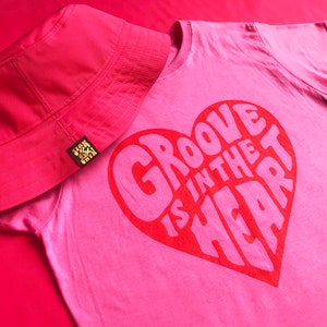 Groove is in the Heart pink tee with a red screen printed bold graphic. 90's nostalgia Music T-shirt inspired by the dance band Deee-Lite. Funky at it's finest. Ladies shaped fit Tshirt.