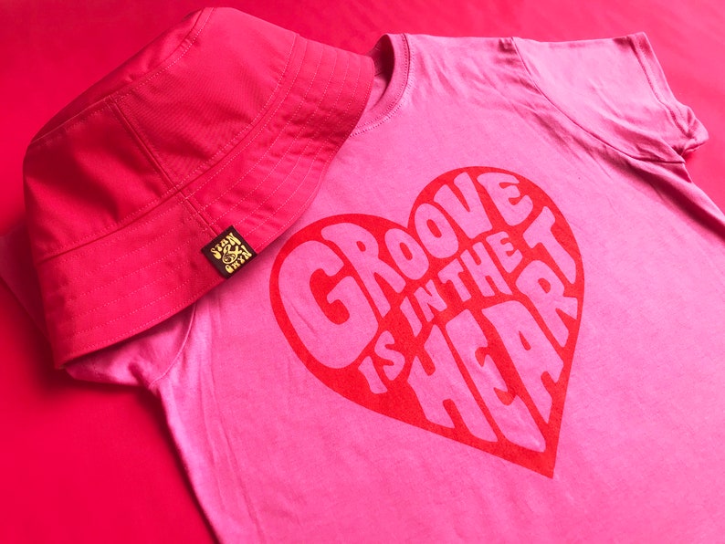 Groove is in the Heart pink tee with a red screen printed bold graphic. 90's nostalgia Music T-shirt inspired by the dance band Deee-Lite. Funky at it's finest. Ladies shaped fit Tshirt.