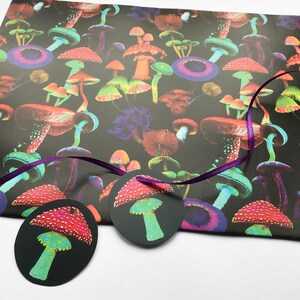 Puede incluir: Un fondo negro est&aacute; cubierto de ilustraciones de setas coloridas. Dos etiquetas de regalo ovaladas con dise&ntilde;os de setas est&aacute;n unidas a una cinta morada. Las etiquetas y el papel de regalo son perfectos para un regalo tem&aacute;tico de la naturaleza.