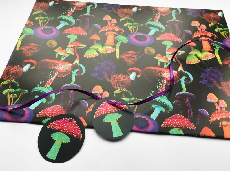 Puede incluir: Un fondo negro est&aacute; cubierto de ilustraciones de setas coloridas. Dos etiquetas de regalo ovaladas con dise&ntilde;os de setas est&aacute;n unidas a una cinta morada. Las etiquetas y el papel de regalo son perfectos para un regalo tem&aacute;tico de la naturaleza.