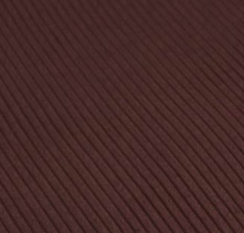 May include: A dark brown fabric featuring a distinct ribbed texture with parallel vertical lines running across the surface. The material displays a consistent deep chocolate tone throughout, characterized by a repeating raised corded pattern.
