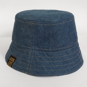 May include: A blue denim bucket hat with a brown patch on the side that says "Stay & Create".