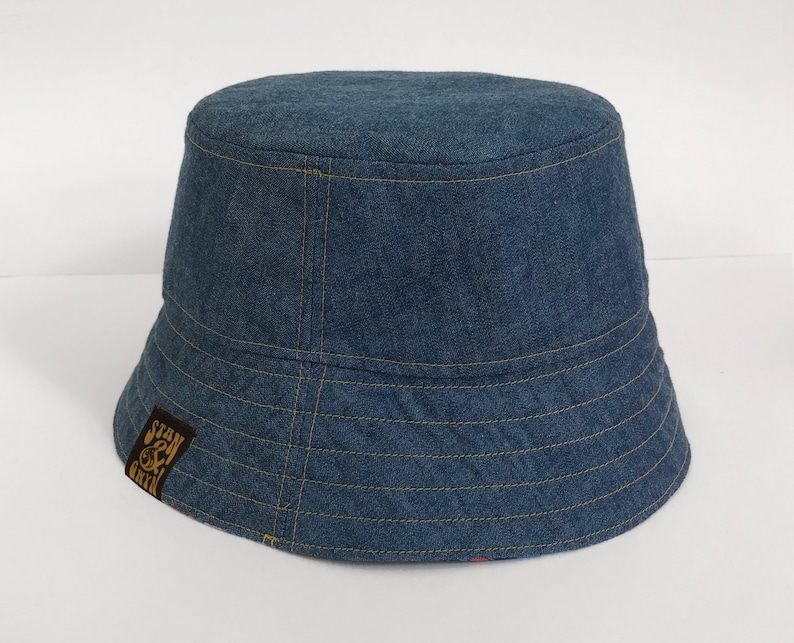 May include: A blue denim bucket hat with a brown patch on the side that says "Stay & Create".