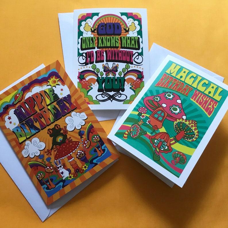 Op de afbeelding: Drie kleurrijke wenskaarten met psychedelische ontwerpen. De eerste kaart heeft een regenboogachtergrond met de tekst "God Only Knows What I'd Be Without You". De tweede kaart heeft een groene achtergrond met de tekst "Magical Birthday Wishes". De derde kaart heeft een oranje achtergrond met de tekst "Happy Birthday".