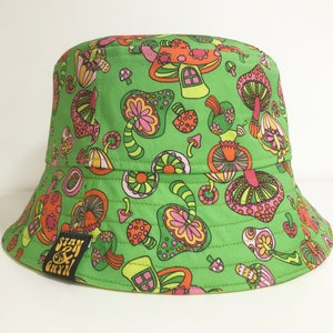 May include: Green bucket hat with a psychedelic mushroom print. The hat has a black label with the text "Stan & Bryn".