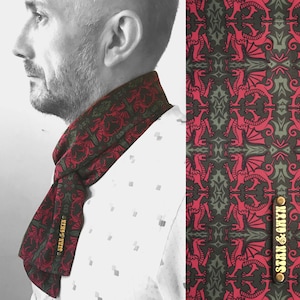 May include: A red and green patterned scarf with a dragon design. The scarf has a gold label with the text "Sean & Owen" on it.