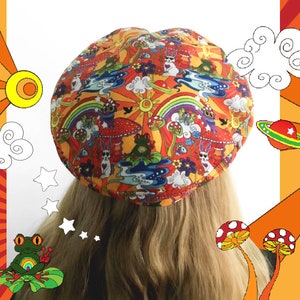 Könnte beinhalten: Eine bunte Baskenmütze mit einem psychedelischen Muster aus Pilzen, Regenbögen, Wolken und Sternen. Die Baskenmütze ist aus Stoff und hat eine abgerundete Form.
