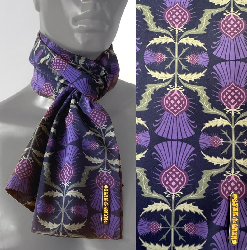 May include: A dark blue silk scarf with a repeating pattern of purple and pink thistles. The scarf has a gold label that says "Silk & Thistle".