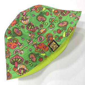 May include: Green bucket hat with a psychedelic mushroom print and the text "Seen & Green" in black.