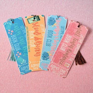 May include: Four colorful bookmarks with tassel accents. Each bookmark features unique text, including "Only One Idea," "Slow Burn," "Crushy & Cosmos," and "Small Town Romance." The bookmarks have a vintage ticket design with decorative elements.