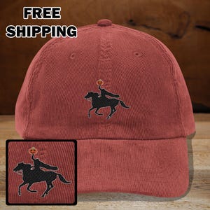 May include: A brick-red corduroy baseball cap featuring an embroidered black silhouette of the Headless Horseman riding a horse, with a pumpkin head. The words "FREE SHIPPING" are printed in white on the top left of the cap.