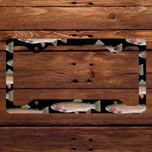 May include: Black license plate frame with a repeating pattern of rainbow trout on a black background.
