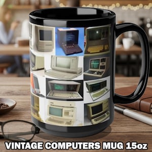 May include: Black ceramic mug featuring a collage of vintage computers. The mug has a black handle and the text "VINTAGE COMPUTERS MUG 15oz" at the bottom. The mug is sitting on a wooden surface.