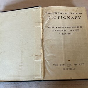 May include: A vintage book titled "Pronouncing and Spelling Dictionary" specially adapted for students of The Bennett College, Sheffield.