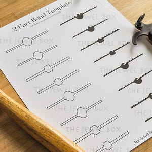 May include: A sheet with a 2 Part Band Template design, with various shapes and cut lines, is next to a hammer and a metal saw. The hammer has a wooden handle and a metal head. The text "The Jewel Box" is visible.