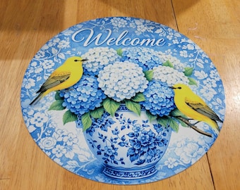 Welcome sign with hydrangeas and yellow warblers.