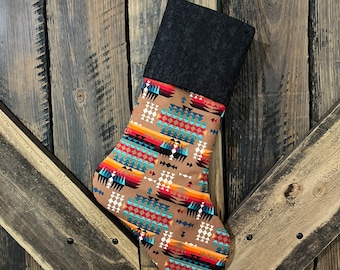 May include: A brown and black Christmas stocking with a geometric pattern. The stocking is hanging on a wooden door.