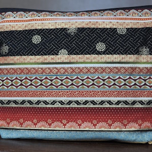 May include: A black and red striped zippered pouch with a colorful geometric pattern. The pouch is made of fabric and has a zipper closure.