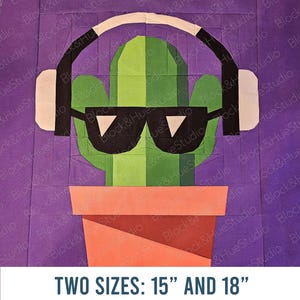 May include: A fabric art piece depicting a cactus wearing sunglasses and headphones. The cactus is in a terracotta pot. The text at the bottom reads "TWO SIZES: 38 cm AND 46 cm".