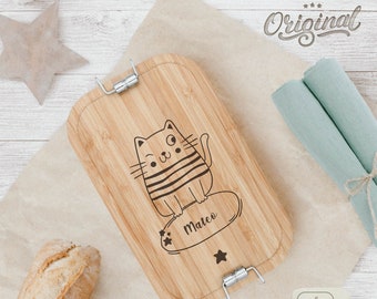 May include: A wooden cutting board with a cat design and the name "Mateo" engraved on it. The board has a metal clasp and is made of bamboo.