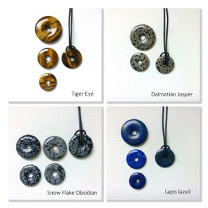 May include: Four sets of gemstone pendants, each with a different stone: Tiger Eye, Dalmatian Jasper, Snow Flake Obsidian, and Lapis Lazuli. Each set includes three pendants of varying sizes, all with a hole for a cord or chain.